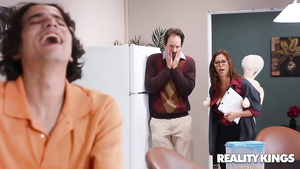 Busty brunette in glasses sits down on a lad on chair